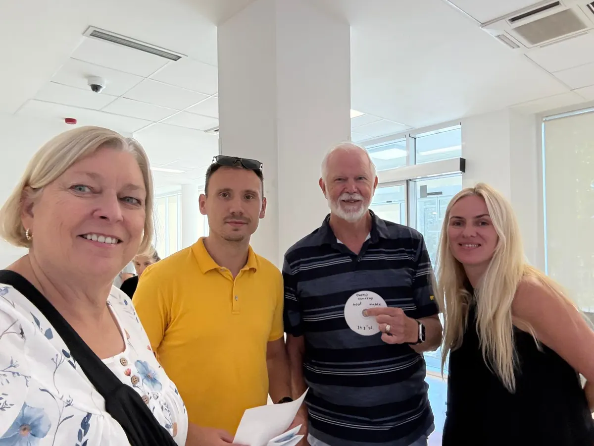 TMASI representatives with guests after their hospital visit, holding the scan disc